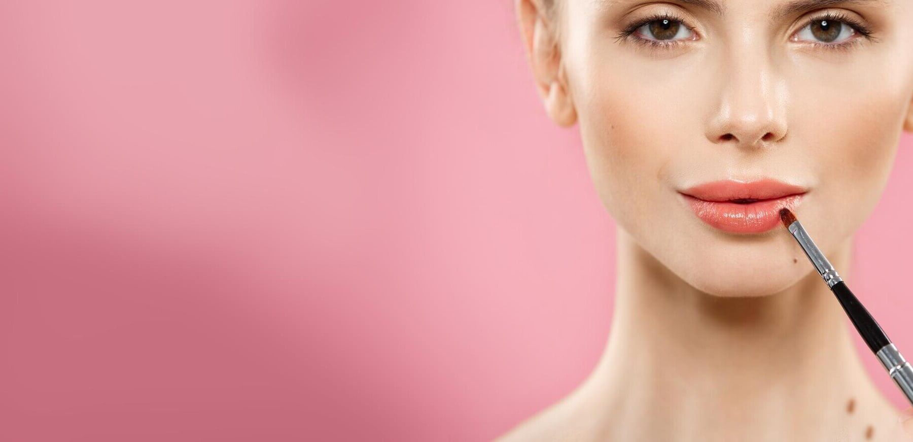 beauty concept woman applying red lipstick with pink studio background beautiful girl makes makeup beauty concept woman applying red lipstick with pink studio background beautiful girl makes makeup